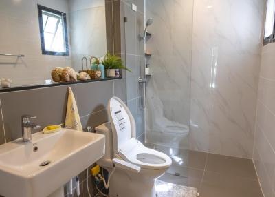 Modern bathroom interior with a glass shower, toilet and sink
