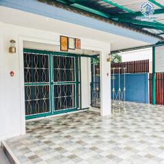 Front entrance of a residential building with tiled flooring and security grille doors