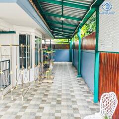 Covered residential patio with tiled flooring and outdoor seating