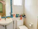 Bright bathroom with white fixtures and blue tile accents