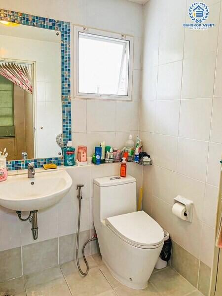 Bright bathroom with white fixtures and blue tile accents