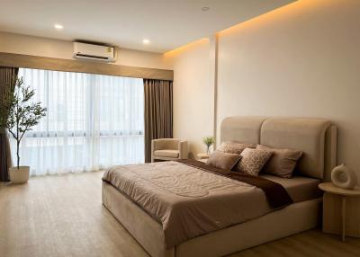 Spacious master bedroom with modern decor and ample lighting
