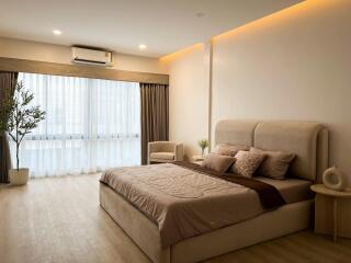 Spacious master bedroom with modern decor and ample lighting