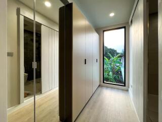 Modern hallway with built-in wardrobes and floor-to-ceiling window