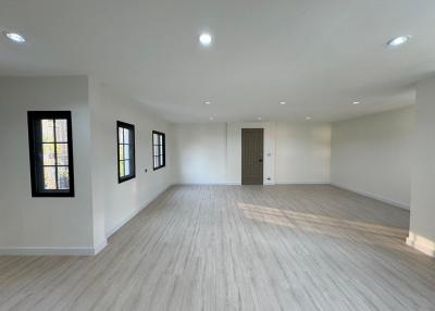 Spacious and well-lit empty interior space with hardwood flooring