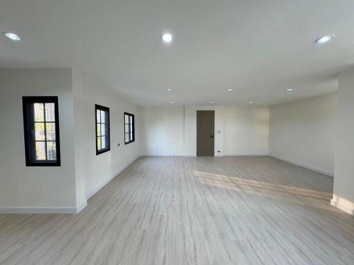 Spacious and well-lit empty interior space with hardwood flooring