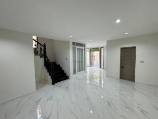 Spacious interior view of a modern building with polished marble floors, staircase, and ample lighting