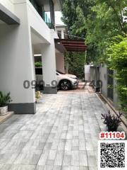 Paved driveway leading to a modern building with a car parked outside