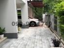 Paved driveway leading to a modern building with a car parked outside