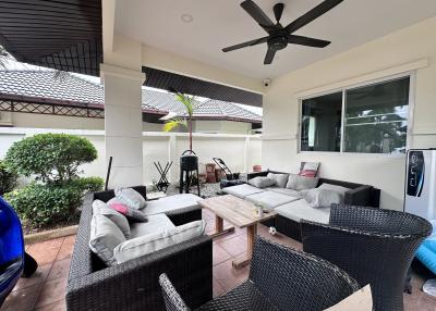 Spacious covered patio with comfortable seating and ceiling fan