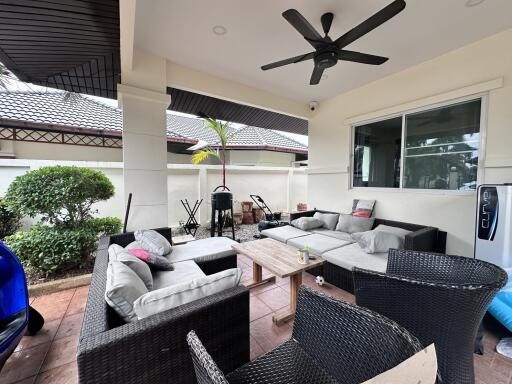 Spacious covered patio with comfortable seating and ceiling fan