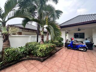 Spacious driveway with palm trees and tiled flooring in residential property