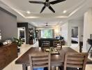 Spacious dining room with adjoining living room, featuring a modern dining set, ceiling fan, and ample natural light