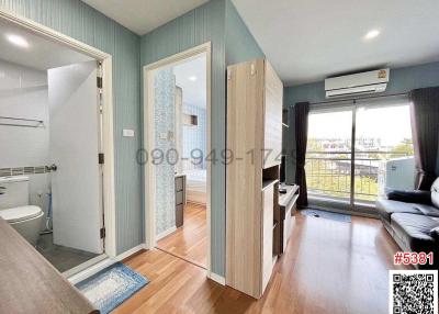 Cozy bedroom with ensuite bathroom, wooden flooring, wardrobe, and air conditioning