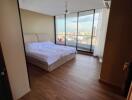 Spacious bedroom with large windows and city view