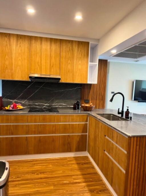 Modern kitchen with wooden cabinets and black marble countertop