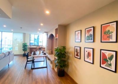 Spacious living room with hardwood flooring and wall art