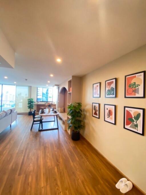 Spacious living room with hardwood flooring and wall art