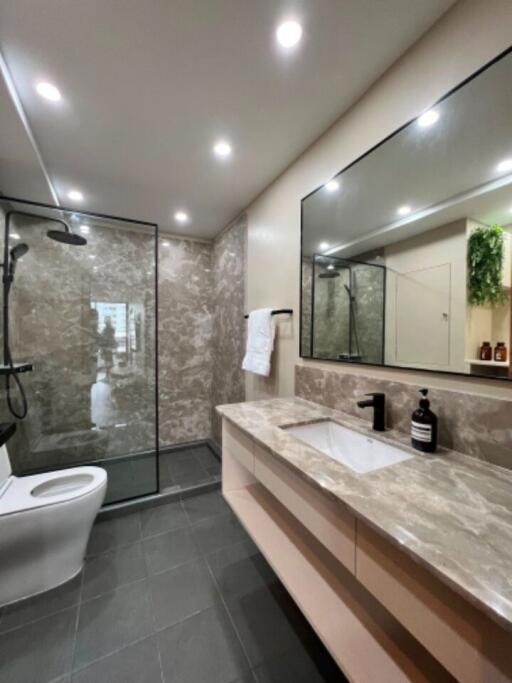 Modern bathroom with spacious glass shower, sleek design, and well-lit vanity area