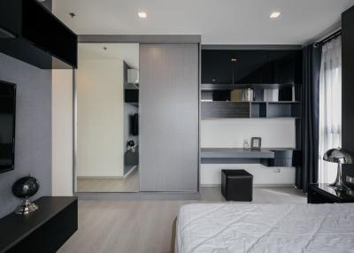 Modern bedroom with integrated living space, featuring sleek design and neutral tones
