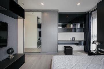 Modern bedroom with integrated living space, featuring sleek design and neutral tones