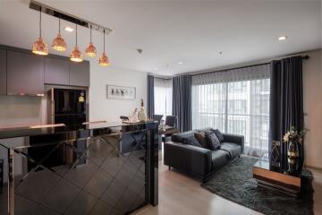 Modern living room with open kitchen design, comfortable seating, and abundant natural light