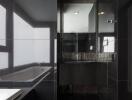 Modern bathroom interior with dark tiles featuring a bathtub and a vanity