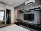 Modern bedroom interior with mounted television and air conditioning unit