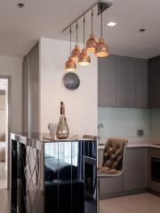 Modern kitchen with bar stools and stylish pendant lights