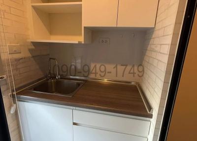 Compact modern kitchen with white cabinetry and stainless steel sink