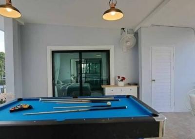Spacious game room with pool table and balcony access in modern home