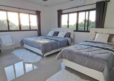 Spacious bedroom with two beds and large windows
