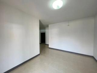 Empty interior of a residential space showing tiled floors and white walls