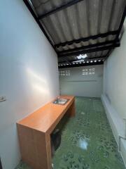 Compact kitchen space with tiled countertop and sink, under a partially open ceiling