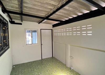 Basement area with exposed beams and green flooring