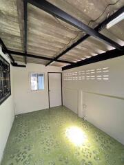 Basement area with exposed beams and green flooring