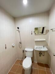 Compact bathroom with white fixtures including toilet, sink, and shower