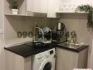 Compact modern kitchen with integrated appliances and washing machine