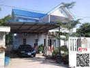 Exterior view of a two-story house with blue roof and carport