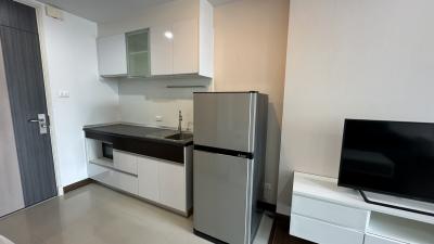 Compact modern kitchen with appliances and adjacent living area