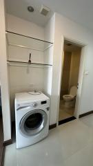 Compact laundry room with washing machine and built-in shelves