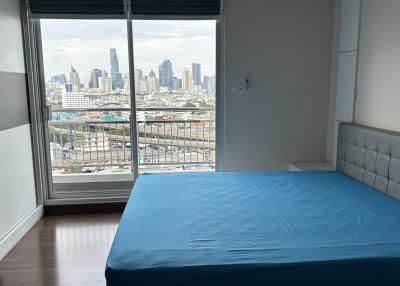 Modern bedroom with large windows and city view