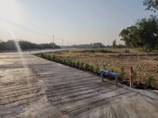 Empty plot of land with a concrete road leading to the horizon