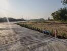 Empty plot of land with a concrete road leading to the horizon