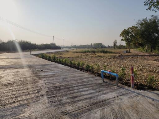 Empty plot of land with a concrete road leading to the horizon