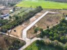 Aerial view of a large vacant land plot with nearby housing and agricultural fields