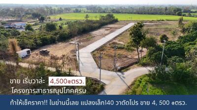 Aerial view of a vacant land plot with surrounding greenery and a concrete path