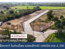 Aerial view of a vacant land plot with surrounding greenery and a concrete path