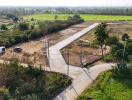 Aerial view of an open land property with access roads and surrounding greenery