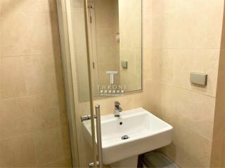 Modern bathroom interior with a glass shower cubicle, sink, and beige tiles